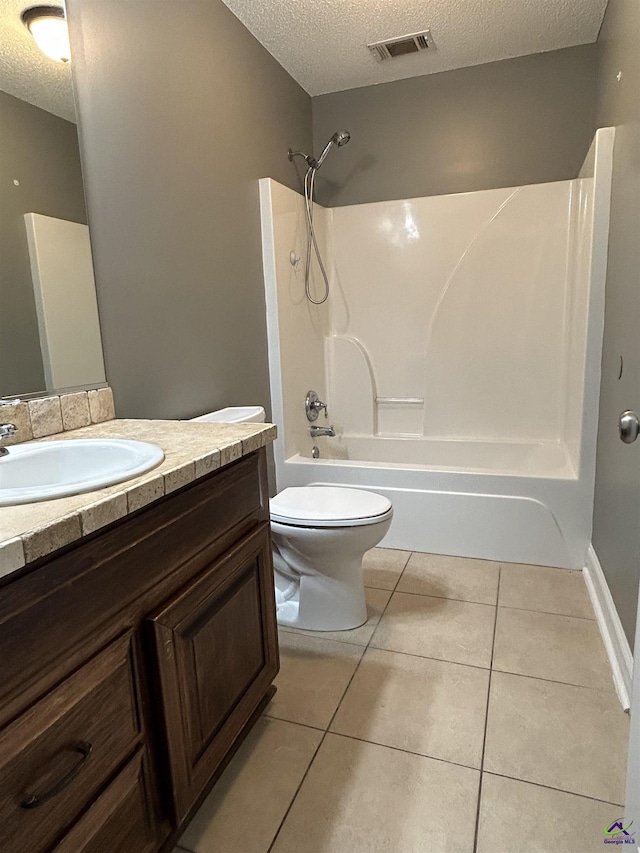 228 Piedmont Ln, Bonaire, GA 31005 - bathroom featuring a textured ceiling, vanity, tub / shower combination, and tile patterned floors