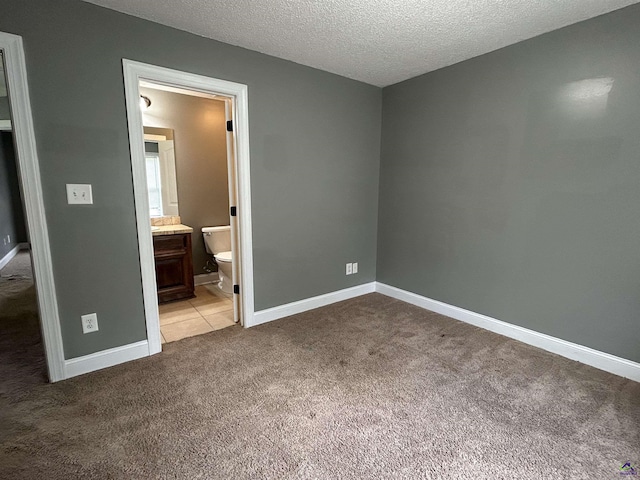 228 Piedmont Ln, Bonaire, GA 31005 - unfurnished bedroom with carpet floors, a textured ceiling, and connected bathroom