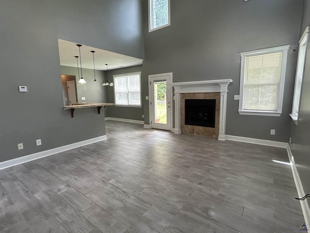 228 Piedmont Ln, Bonaire, GA 31005 - unfurnished living room with a tile fireplace, a towering ceiling, and dark wood-style floors