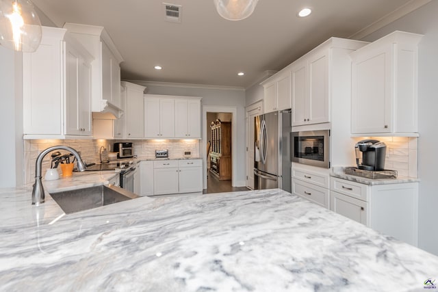 202 Brook Hollow Ct, Kathleen, GA 31047 - kitchen with appliances with stainless steel finishes, crown molding, light stone counters, white cabinets, and recessed lighting