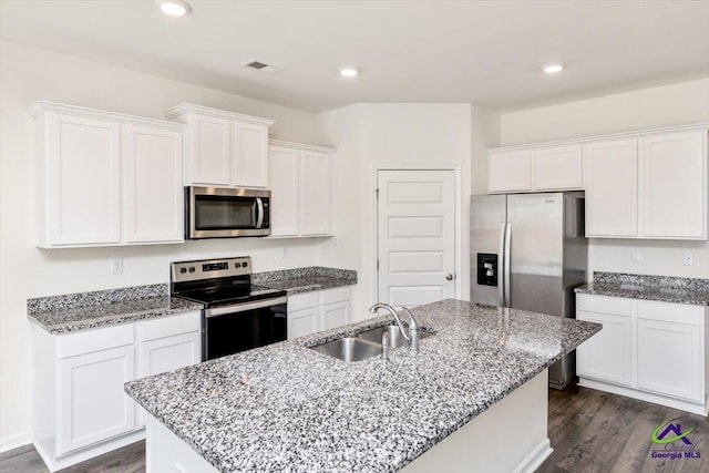 111 Farmers Way, Perry, GA 31069 - kitchen featuring stainless steel appliances, white cabinetry, dark wood-style floors, an island with sink, and light stone counters