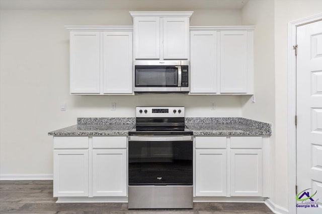 111 Farmers Way, Perry, GA 31069 - kitchen featuring appliances with stainless steel finishes, white cabinets, dark wood-type flooring, and light stone countertops