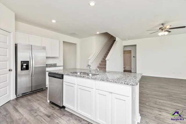 111 Farmers Way, Perry, GA 31069 - kitchen with appliances with stainless steel finishes, ceiling fan, an island with sink, white cabinetry, and light wood-style flooring