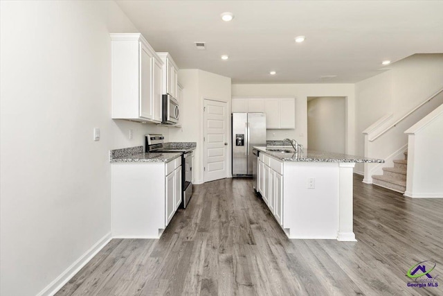 111 Farmers Way, Perry, GA 31069 - kitchen with stainless steel appliances, light wood-style flooring, white cabinets, light stone countertops, and recessed lighting