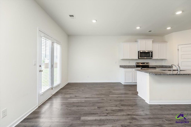 111 Farmers Way, Perry, GA 31069 - kitchen with appliances with stainless steel finishes, dark stone counters, recessed lighting, white cabinetry, and dark wood-style floors