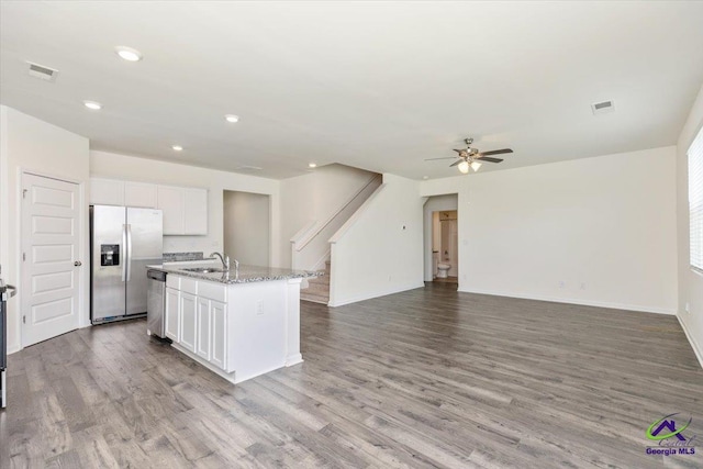 111 Farmers Way, Perry, GA 31069 - kitchen featuring appliances with stainless steel finishes, a ceiling fan, open floor plan, white cabinetry, and wood finished floors