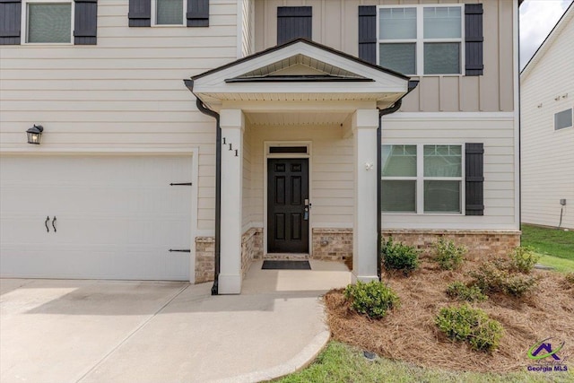 111 Farmers Way, Perry, GA 31069 - doorway to property featuring an attached garage, stone siding, driveway, and board and batten siding