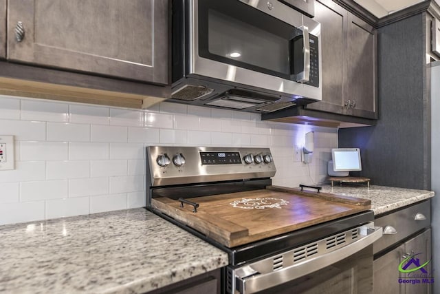501 Adirondac Way, Bonaire, GA 31005 - kitchen with appliances with stainless steel finishes, backsplash, dark brown cabinets, and light stone countertops