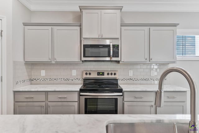 104 Taylor Leigh Ct, Kathleen, GA 31047 - kitchen with stainless steel appliances, crown molding, decorative backsplash, gray cabinetry, and light stone counters