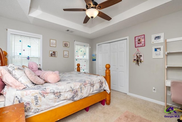 222 Duke Ln, Kathleen, GA 31047 - bedroom featuring a tray ceiling, light colored carpet, a closet, and a ceiling fan