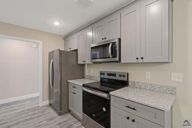 219 Christine Cir, Perry, GA 31069 - kitchen with stainless steel appliances, gray cabinetry, light wood-type flooring, and light stone countertops