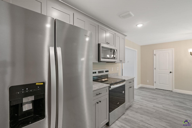219 Christine Cir, Perry, GA 31069 - kitchen featuring stainless steel appliances, light stone countertops, light wood-style flooring, gray cabinets, and recessed lighting