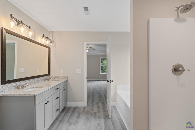 219 Christine Cir, Perry, GA 31069 - full bathroom with wood finished floors, double vanity, a garden tub, and a ceiling fan