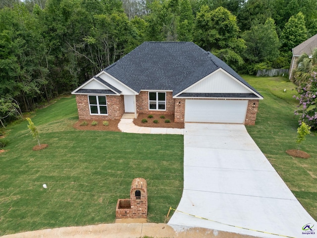 219 Christine Cir, Perry, GA 31069 - view of front of home with brick siding, concrete driveway, a front lawn, an attached garage, and roof with shingles