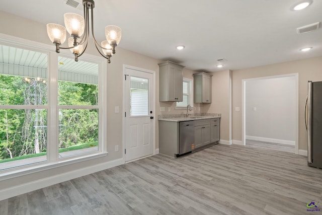 219 Christine Cir, Perry, GA 31069 - kitchen with gray cabinets, stainless steel appliances, light wood-style floors, a chandelier, and light stone counters