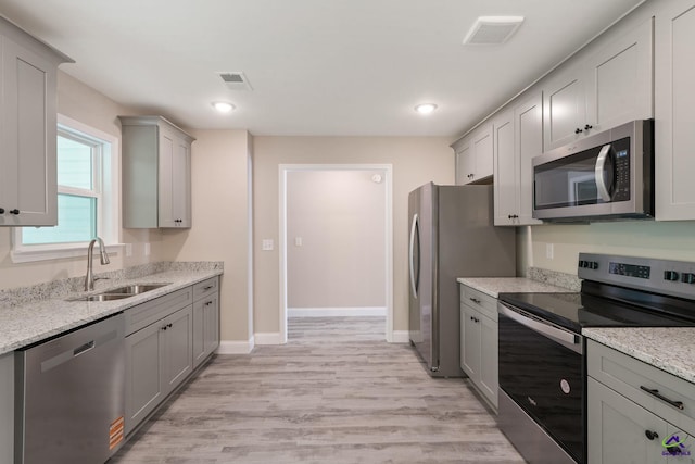 219 Christine Cir, Perry, GA 31069 - kitchen featuring appliances with stainless steel finishes, gray cabinetry, light wood-type flooring, light stone counters, and recessed lighting