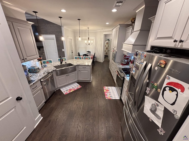 400 Rustic Live Oak Trl, Bonaire, GA 31005 - kitchen featuring appliances with stainless steel finishes, a peninsula, dark wood-style flooring, custom exhaust hood, and light stone countertops