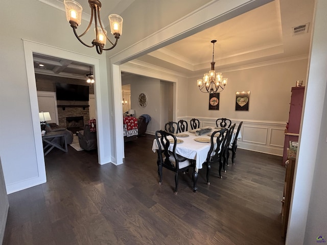 400 Rustic Live Oak Trl, Bonaire, GA 31005 - dining room featuring a chandelier, crown molding, a tray ceiling, dark wood-style flooring, and a fireplace