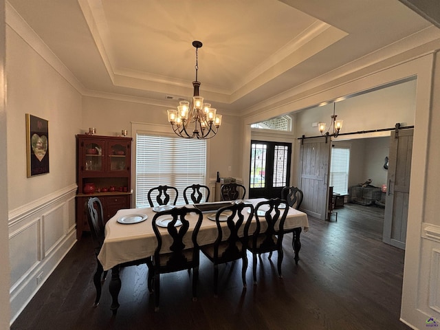400 Rustic Live Oak Trl, Bonaire, GA 31005 - dining room featuring a chandelier, a raised ceiling, a barn door, dark wood-style floors, and a decorative wall