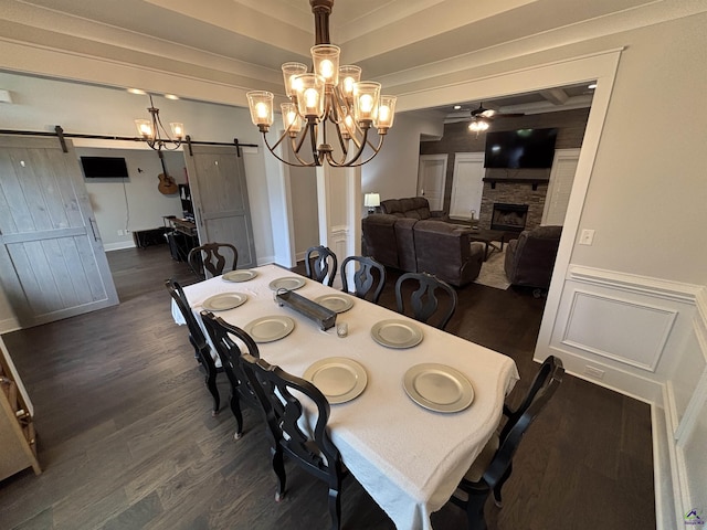 400 Rustic Live Oak Trl, Bonaire, GA 31005 - dining room with a barn door, ceiling fan, dark wood finished floors, a stone fireplace, and a decorative wall