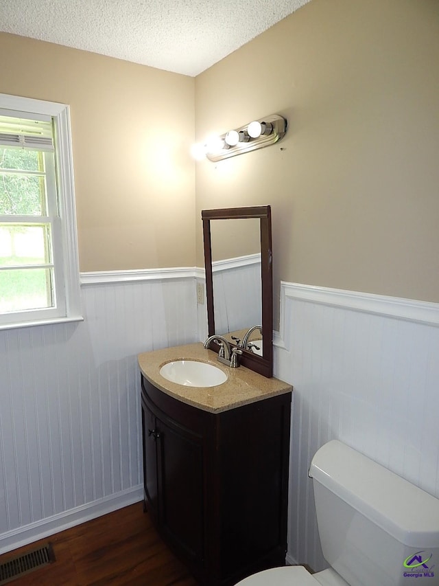 3498 Sandy Cir, Macon, GA 31216 - bathroom with a wainscoted wall, wood finished floors, vanity, and a textured ceiling