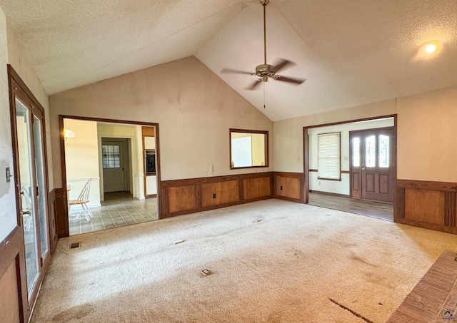 7285 Nowell Rd S, Macon, GA 31216 - unfurnished room featuring wainscoting, vaulted ceiling, ceiling fan, carpet flooring, and a textured ceiling