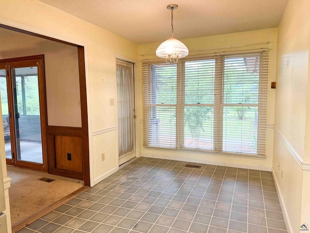 7285 Nowell Rd S, Macon, GA 31216 - unfurnished dining area with a chandelier, a textured ceiling, light tile patterned floors, and wainscoting