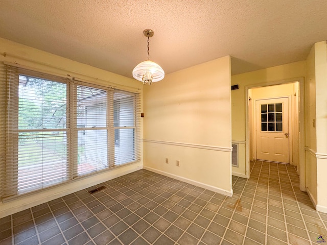 7285 Nowell Rd S, Macon, GA 31216 - unfurnished dining area with a textured ceiling, tile patterned flooring, and a chandelier