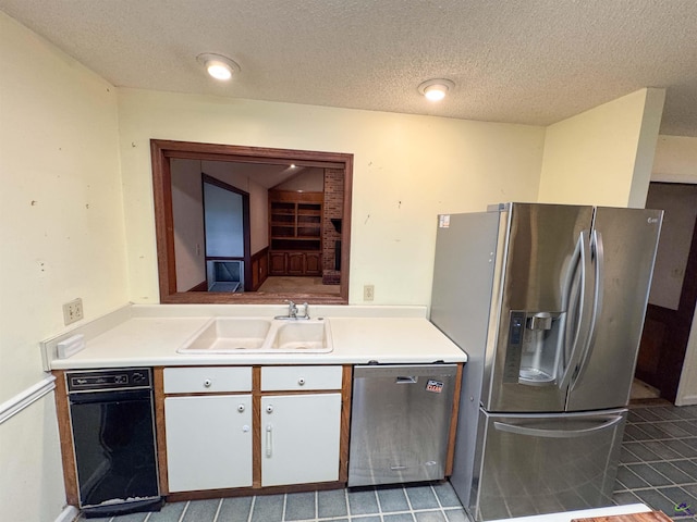 7285 Nowell Rd S, Macon, GA 31216 - kitchen with stainless steel appliances, light countertops, white cabinetry, tile patterned flooring, and a textured ceiling