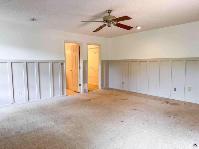 7285 Nowell Rd S, Macon, GA 31216 - spare room featuring ceiling fan, carpet, wainscoting, a textured ceiling, and a decorative wall