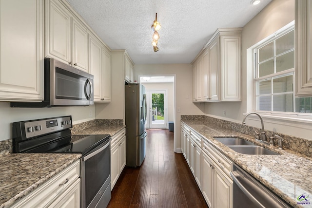 109 S Hiley Ct, Bonaire, GA 31005 - kitchen with stainless steel appliances, dark wood-style floors, light stone countertops, cream cabinets, and a textured ceiling