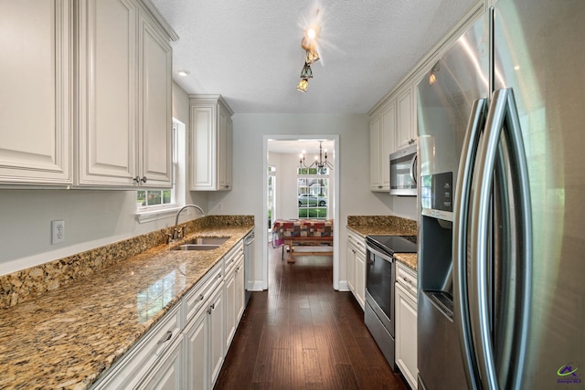 109 S Hiley Ct, Bonaire, GA 31005 - kitchen with appliances with stainless steel finishes, dark wood finished floors, light stone counters, a chandelier, and white cabinets