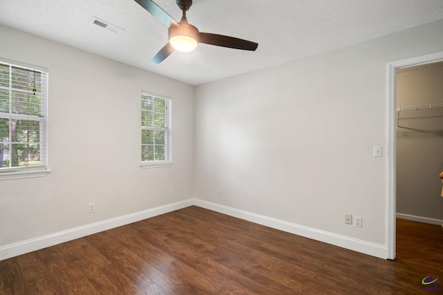 109 S Hiley Ct, Bonaire, GA 31005 - unfurnished bedroom with a spacious closet, dark wood-style flooring, a closet, a ceiling fan, and a textured ceiling