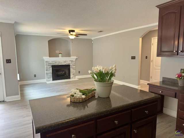 145 Rolling Woods Cir, Warner Robins, GA 31088 - kitchen featuring a ceiling fan, crown molding, arched walkways, a textured ceiling, and a kitchen island