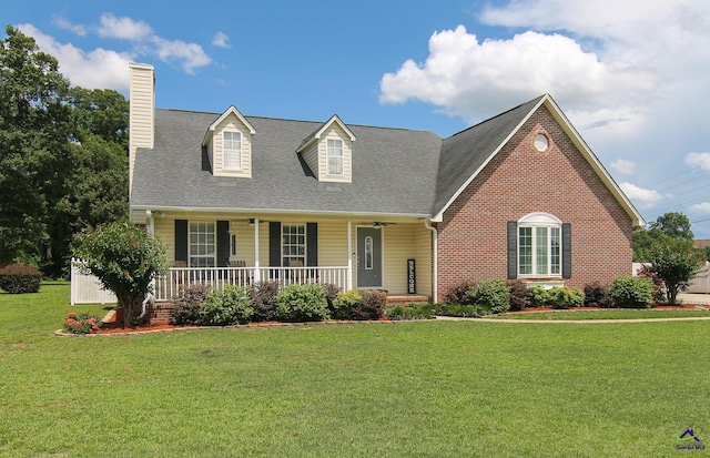 100 Scarlett Dr, Warner Robins, GA 31088 - new england style home with a porch, a chimney, a front yard, a shingled roof, and brick siding
