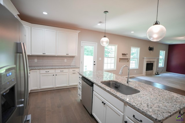 133 W River Cane Run, Perry, GA 31069 - kitchen with stainless steel appliances, dark wood finished floors, a fireplace with flush hearth, white cabinets, and open floor plan