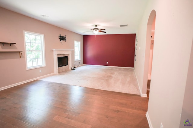 133 W River Cane Run, Perry, GA 31069 - unfurnished living room featuring ceiling fan, arched walkways, a high end fireplace, and wood finished floors
