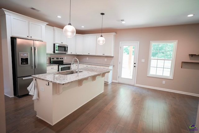 133 W River Cane Run, Perry, GA 31069 - kitchen with stainless steel appliances, backsplash, a kitchen breakfast bar, white cabinets, and an island with sink