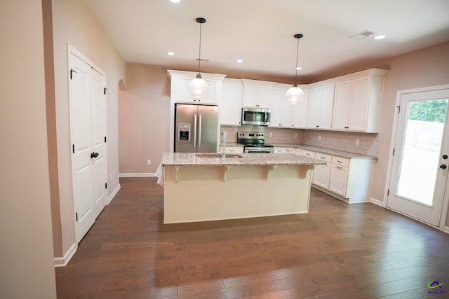 133 W River Cane Run, Perry, GA 31069 - kitchen with stainless steel appliances, backsplash, white cabinets, dark wood-style flooring, and a kitchen breakfast bar
