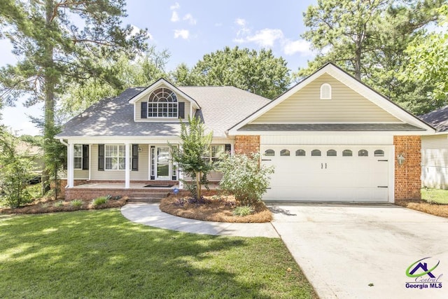 310 Woods Edge Way, Warner Robins, GA 31088 - view of front of property featuring a garage, concrete driveway, a front yard, covered porch, and a shingled roof