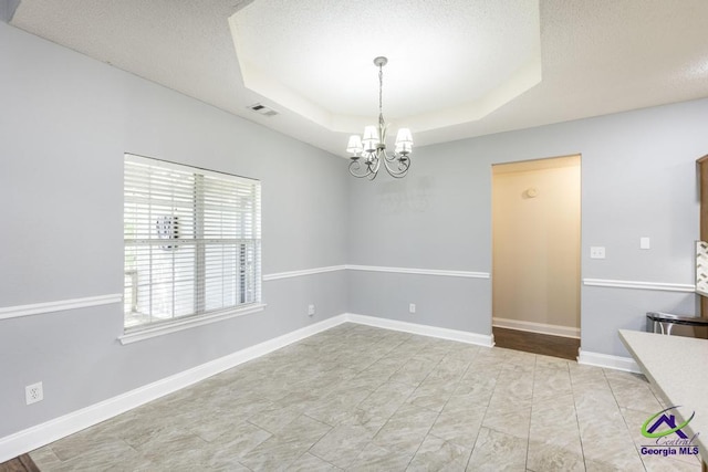 310 Woods Edge Way, Warner Robins, GA 31088 - unfurnished room featuring a chandelier, a textured ceiling, and a raised ceiling