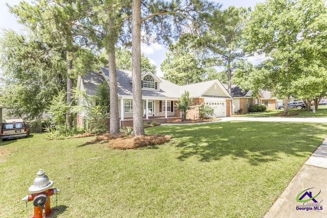 310 Woods Edge Way, Warner Robins, GA 31088 - view of front of home with concrete driveway, a front lawn, a garage, brick siding, and covered porch