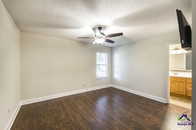 310 Woods Edge Way, Warner Robins, GA 31088 - unfurnished bedroom featuring dark wood-style flooring, a textured ceiling, ensuite bath, and a ceiling fan