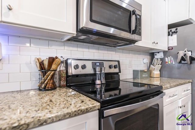 103 Cascades Ct, Bonaire, GA 31005 - kitchen with stainless steel appliances, decorative backsplash, white cabinets, and light stone countertops