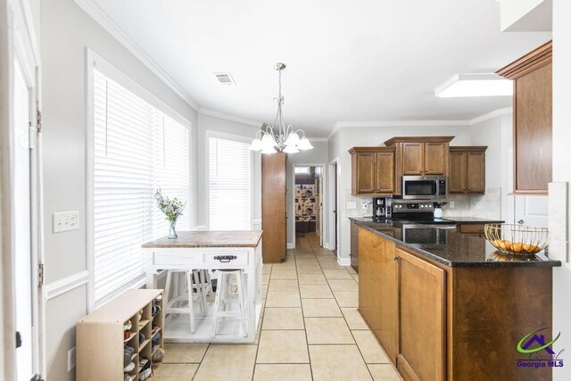 112 Verandah Ct, Bonaire, GA 31005 - kitchen with appliances with stainless steel finishes, a chandelier, brown cabinetry, tasteful backsplash, and crown molding