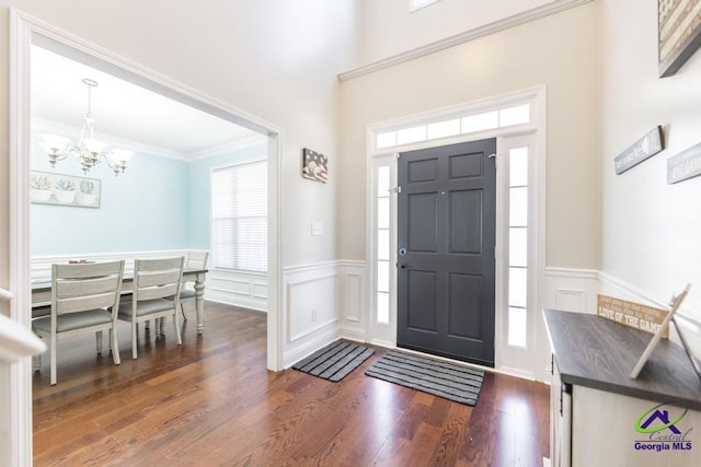 112 Verandah Ct, Bonaire, GA 31005 - entryway featuring a chandelier, a wainscoted wall, dark wood-style flooring, a decorative wall, and ornamental molding