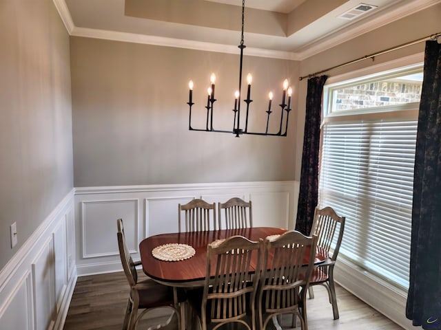 109 Raspberry Trl, Perry, GA 31069 - dining area with wood finished floors, a chandelier, a decorative wall, crown molding, and a wainscoted wall