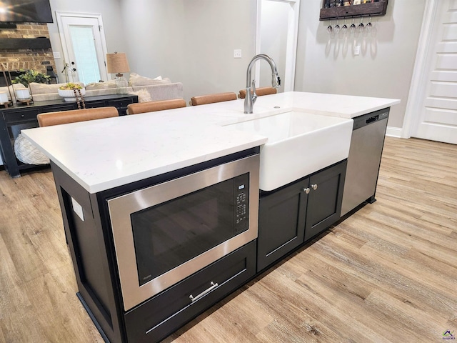 109 Raspberry Trl, Perry, GA 31069 - kitchen with light wood-style floors, appliances with stainless steel finishes, open floor plan, and an island with sink