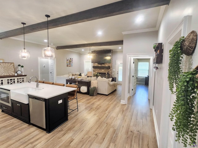 109 Raspberry Trl, Perry, GA 31069 - kitchen with dark cabinets, dishwasher, beam ceiling, light wood finished floors, and a large fireplace