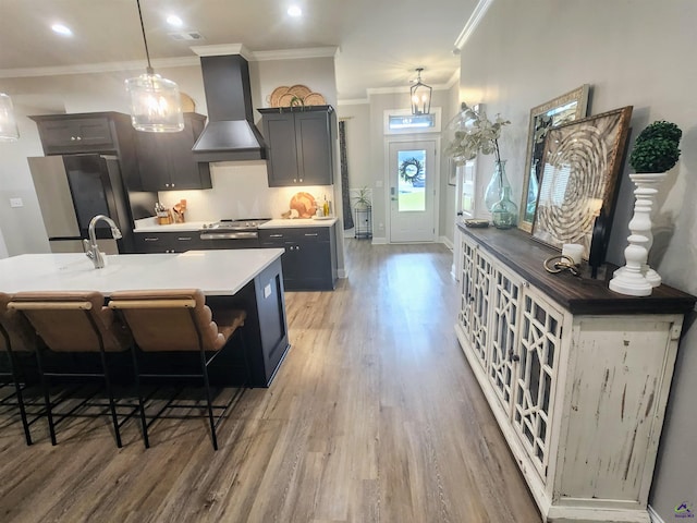 109 Raspberry Trl, Perry, GA 31069 - kitchen with custom exhaust hood, freestanding refrigerator, ornamental molding, light wood-type flooring, and a kitchen breakfast bar